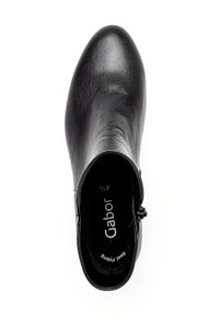 Bottine en cuir noir avec un bout arrondi, texture lisse, fermeture éclaire sur le côté et doublure intérieure douce. Marque "Gabor" visible à l'intérieur.