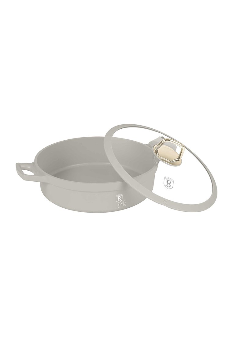 Casserole grise ronde avec des poignées et un couvercle en verre transparent avec un bouton doré, positionnée partiellement ouverte.