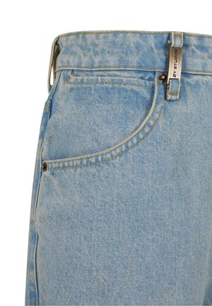 Light blue denim jeans featuring a high waist, front pocket, yellow stitching, and a metal tag on the waistband.