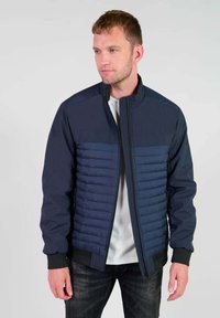 Marineblauwe jas met gewatteerde panelen, hoge kraag, ritssluiting en geribde manchetten. Gemaakt van een gladde, duurzame stof. Casual ontwerp.