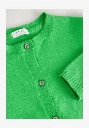 Zielony dziergany kardigan z okrągłym dekoltem, widocznymi guzikami i naszywką z napisem "NEXT Made in Bangladesh".