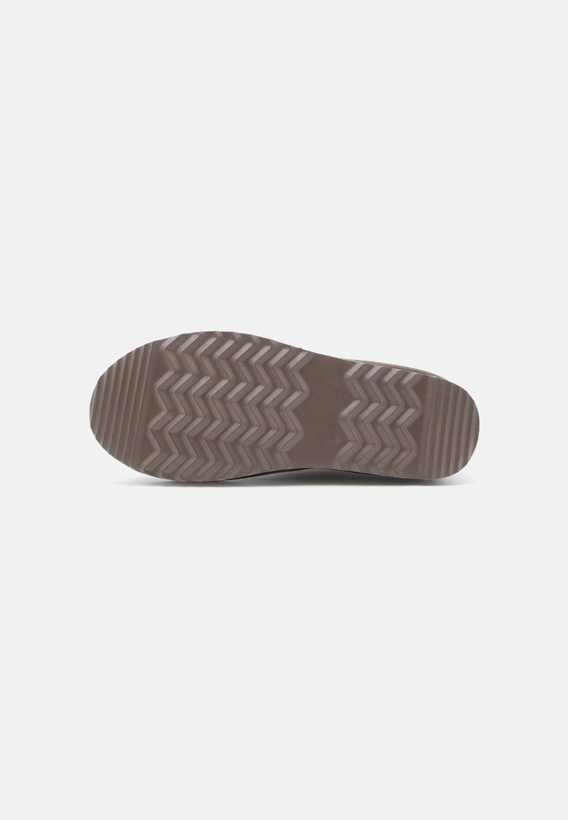 Schuhsohle aus einem strukturierten Gummimaterial, mit einem Zickzackmuster in Brauntönen und hellem Taupe. Flach mit einer abgerundeten Form.