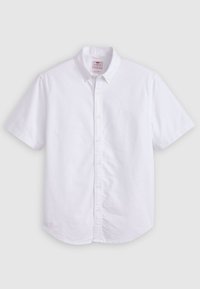 Biała koszula zapinana na guziki z krótkim rękawem wykonana z bawełny. Posiada klasyczny kołnierzyk, zapięcie na guziki i zaokrąglony dół bez widocznych wzorów.
