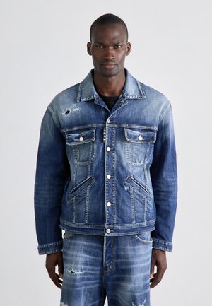 Τζάκετ από τζιν με ξεθωριασμένο μπλε χρώμα, μπροστινές τσέπες, ορατές ραφές και φθορές. Κλασική εφαρμογή με μπροστινά κουμπιά και γιακά.