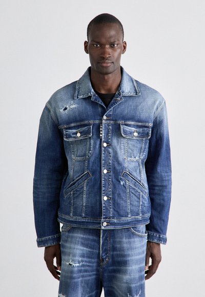 Denim jacket with a faded blue wash, front pockets, visible stitching, and distressed details. Classic fit with front buttons and a collar.