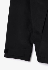 Pantaloni corti neri realizzati in tessuto leggero, dotati di una cintura in velcro e dettagli con logo impresso, con un design pulito e una vestibilità sartoriale.