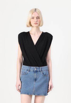 Body negro ajustado con mangas cortas, combinado con una mini falda de mezclilla azul claro, que cuenta con bolsillos y cierre de botones.