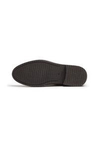 Suela de zapato de goma negra con una superficie texturizada, que presenta estrías horizontales y una forma curvada, diseñada para ofrecer tracción y durabilidad.