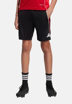 Zwarte sportshorts met rode accentstrepen en wit Adidas-logo, gemaakt van vochtregulerende stof, gecombineerd met zwarte voetbalschoenen en gestreepte sokken.