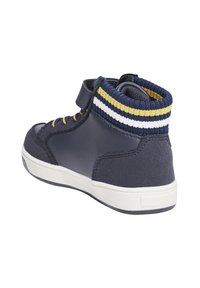 Sneaker alta blu navy con tomaia in pelle e tessuto, dotata di una fascia in velcro, colletto a coste a righe colorate e suola in gomma bianca.