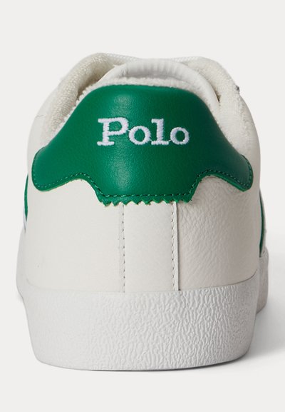 Biely opätok tenisky s textúrovanou podrážkou, zeleným koženým pásikom na päte a nápisom "Polo" vyšitým bielou farbou na pásiku.