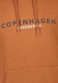 Felpa con cappuccio marrone dotata di tasca frontale, cordini e testo stampato "COPENHAGEN HINDSBERCH" in bianco e nero sul petto.