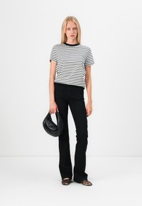 Striped black and white t-shirt, black high-waisted jeans, leopard-print flats, and a black handbag. Simple and modern design.