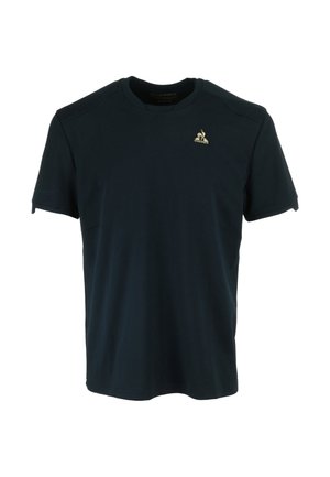 T-shirt in cotone di un blu navy scuro, con maniche corte, scollatura rotonda e un piccolo logo dorato sulla parte sinistra del petto. Tessuto liscio.