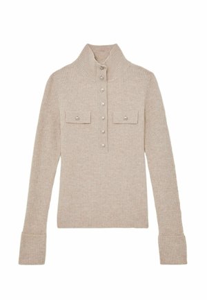 Beige geribbelde trui met een hoge kraag, knoopsluiting aan de voorkant, twee borstzakken en lange mouwen met aansluitende boorden.