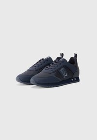 Marineblå sneakers med mesh og syntetisk overdel, snølås design, teksturert såle og logodetaljer. Har et trekkpunkt på hælen.