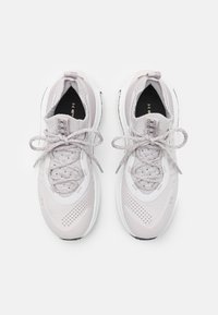 Scarpe da ginnastica grigie chiare con una tomaia traspirante, colletto imbottito e chiusura con lacci. Accenti bianchi e superficie testurizzata per una maggiore aderenza.