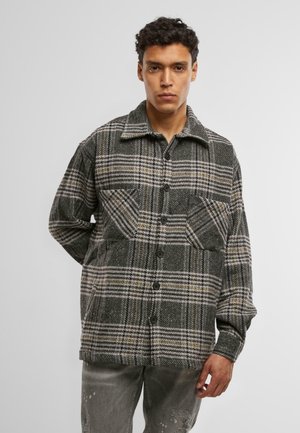 Grijs geruite button-up jas met een kraag, voorzien van zwarte knopen en een textuur zoals wol. Twee voorkanten zakken met een ontspannen pasvorm.