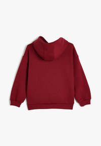 Felpa bordeaux con una texture morbida, dotata di cappuccio, polsini a coste e vestibilità rilassata. Il retro è semplice, senza dettagli aggiuntivi.