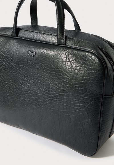 Fekete bőrtáska texturált felülettel, két fogantyúval és cipzáras záródással. Finom, dombornyomott logó részlet az elején.