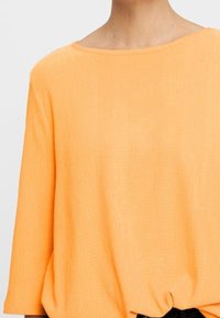Lässiges, kurzes Oberteil mit weit geschnittenen �Ärmeln aus leuchtend orangefarbenem Rippmaterial, mit einem weiten Ausschnitt und einem gerafften Detail am Saum.