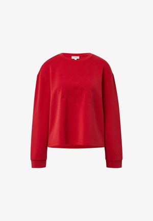 Punane elastses stiilis särgiga, soonikkoes varrukatega, mille esipaneelil on kõrgendatud, tekstuuriga disain, kus on omavahel põimunud "S"-tähed.