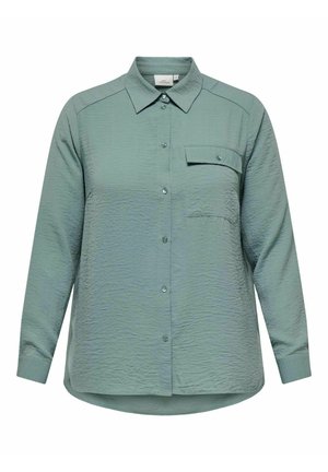 Roheline kortsus kangast särk pika varrukaga, terava kraega, esise nupukinnitus ja üks rinnakott. Ümar noblesse all.