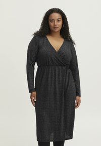 Schwarzes Langarmkleid mit tiefem V-Ausschnitt und gewickeltem Oberteil. Hergestellt aus einem strukturierten, schimmernden Stoff. Knielang.