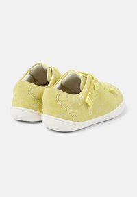 Scarpe in suede gialle con suole in gomma bianca, caratterizzate da un motivo a pois e dettagli cuciti. Progettate con una fascia in Velcro per una facile indossabilità.