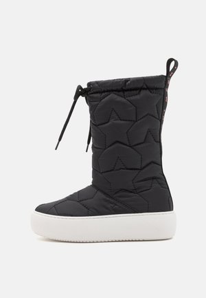 Black, quilted boot featuring star pattern, white rubber sole, and adjustable drawstring. Textured fabric enhances grip and comfort.