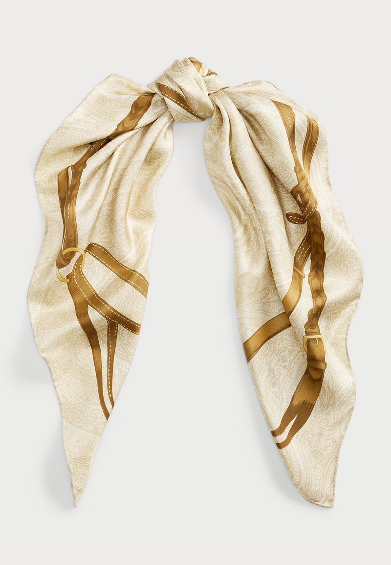 Foulard en soie crème présentant un motif de harnais doré avec des détails intricats. Le design a une texture lisse et une forme fluide, nouée au centre.
