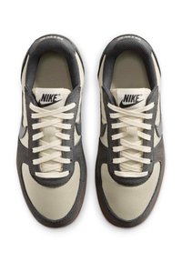 Sneakers Nike z górną częścią z kremowej siateczki, ciemnoszarymi skórzanymi akcentami i białymi sznurowadłami. Posiadają okrągły nos i wyściełany kołnierz dla komfortu.