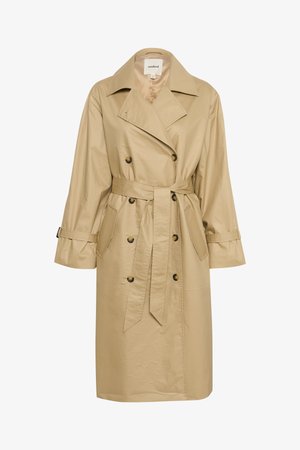 Vaaleanbeige trench-takki, joka on valmistettu sileästä ja kevyestä kankaasta. Takissa on kaksirivinen nappikiinnitys, sivutaskut ja vyötärölle sidottava vyö.