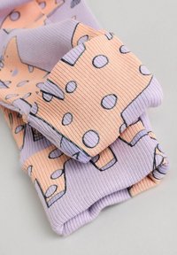 Mønstrede, flerfarvede ribbede sokker med pastelfarvede pink og lilla mønstre i cirkulære og vinklede former. Blød tekstur, rullede manchetter.