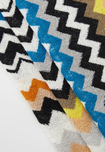 Tessuto multicolore a zigzag con motivi in blu, nero, grigio, bianco, arancione, beige e giallo, realizzato in un materiale morbido e peloso.