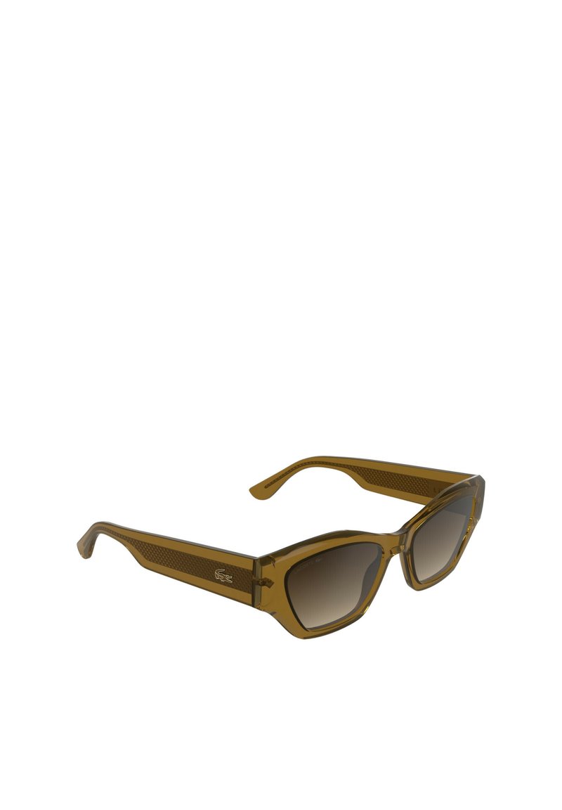 Lunettes de soleil transparentes marron avec une monture angulaire, des verres dégradés et des branches texturées. Présentent le logo Lacoste sur le côté.