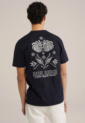 Navy blue cotton t-shirt featuring a silver floral design on the back, with text reading "BLUE RIDGE" and additional decorative elements.