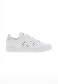 Zapatillas blancas con un acabado de cuero suave, que cuentan con rayas perforadas para ventilación, un acento en el talón de color rosa claro y una suela gruesa blanca.