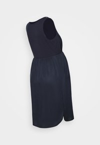 Ærmeløs gravidkjole i mørk navy, med en samlet talje, flydende nederdel og glat stof. Sideskafte detalje nær skulderen.