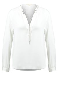 Blouse blanche à manches longues avec détail en chaîne argentée sur le col et décolleté en V, dotée de poignets boutonnés et d'une coupe décontractée.
