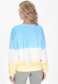 Sudadera ligera de manga larga con un patrón de ombre de azul a amarillo. Textura suave, cuello redondo y puños acanalados para mayor comodidad.