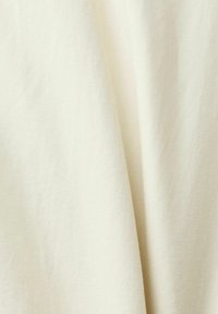 Tessuto di cotone off-white con una consistenza liscia, caratterizzato da sottili motivi a trama diagonale e una caduta morbida.