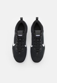 Baskets de sport noires avec une tige en mesh, un swoosh blanc en accent, des lacets ronds et une semelle texturée. Elles disposent d'une boucle au talon pour un enfilage facile.