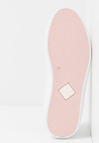 Semelle d'une chaussure de sport rose à semelle en caoutchouc avec une bande de roulement texturée, taille 37 indiquée, et logo GANT avec "EST. 1949" au centre.