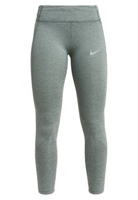 Grå träningsleggings med en slät yta, hög midja och perforerade detaljer vid vaderna. Har en liten vit logotyp.