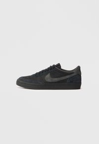 Melnas zamša sporta kurpes ar zemu profilu, gumijas zoli, teksturētām sānu paneļiem un toņos saderīgu Nike swoosh logo. Ar auklēm, ar mīkstu apkakli.