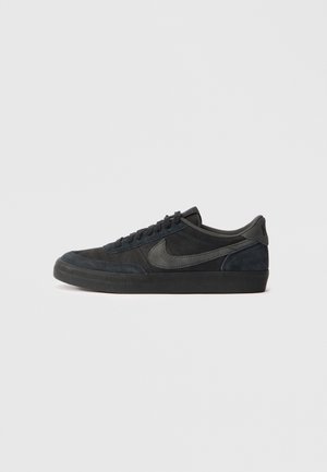 Melnas zamša sporta kurpes ar zemu profilu, gumijas zoli, teksturētām sānu paneļiem un toņos saderīgu Nike swoosh logo. Ar auklēm, ar mīkstu apkakli.