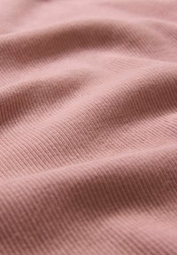 Világos rózsaszínű texturált szövet finom bordázattal és puha megjelenéssel, enyhe hullámokkal és redőkkel. Ideális ruházathoz vagy kárpitozáshoz.