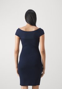 Vestido de color azul marino con escote a los hombros, diseño ajustado, hasta la rodilla y textura suave.
