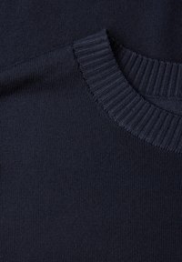 Pull en tricot bleu marine avec un col côtelé et une texture lisse. Le tissu semble doux, avec un motif uniforme et sans ornements visibles.